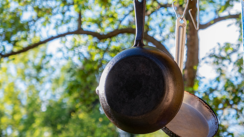 Vintage cast iron pans hanging outdoors