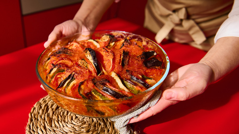 Hands holding ratatouille over table