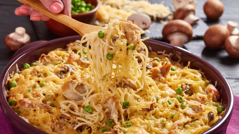 Hand dishing out spoonful of tetrazzini