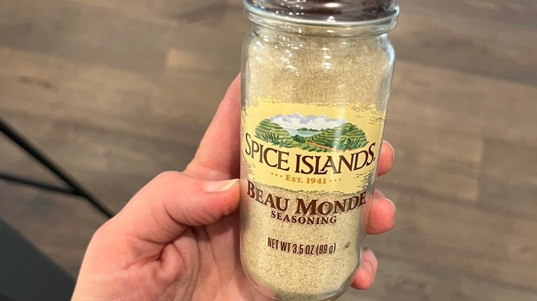 Person holding jar of Beau Monde seasoning