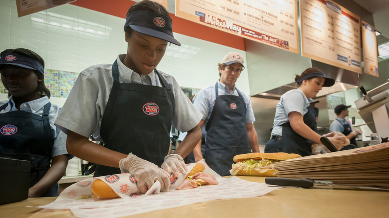 Employees at Jersey Mike's prepping sandwiches.