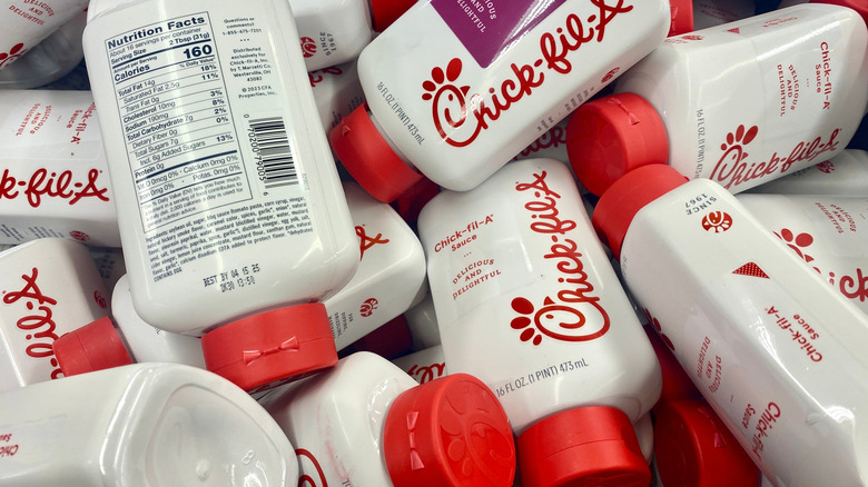Bottles of Chick-fil-A sauce in a pile.