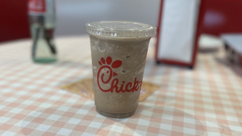 A Chick-fil-A S'mores Frosted Coffee sits on a table.