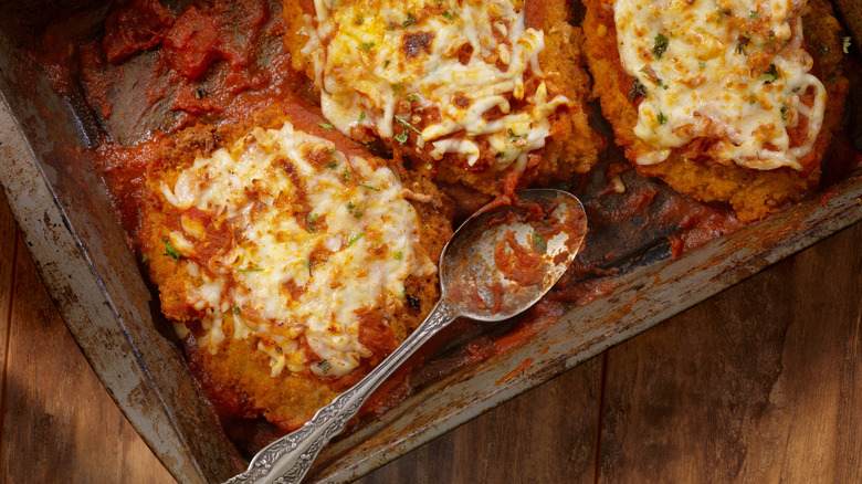 chicken parmesan in baking pan with spoon