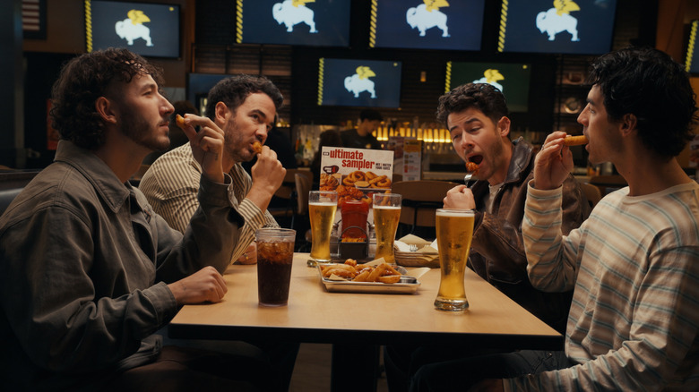 The Jonas Brothers eating Buffalo Wild Wings.