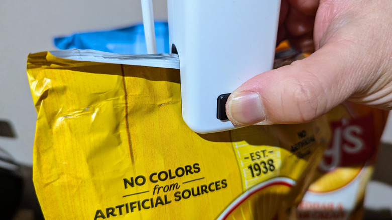 hand using bag sealer on potato chips