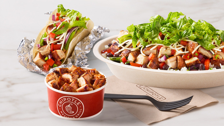 Three Chipotle entrees, including a protein bowl, on marble surface
