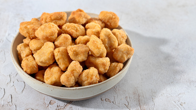 Some breaded chicken chunks in a white bowl