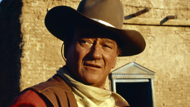 John Wayne wears a Western costume on a film set
