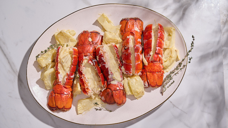 lobster tails coated in cream sauce on a platter