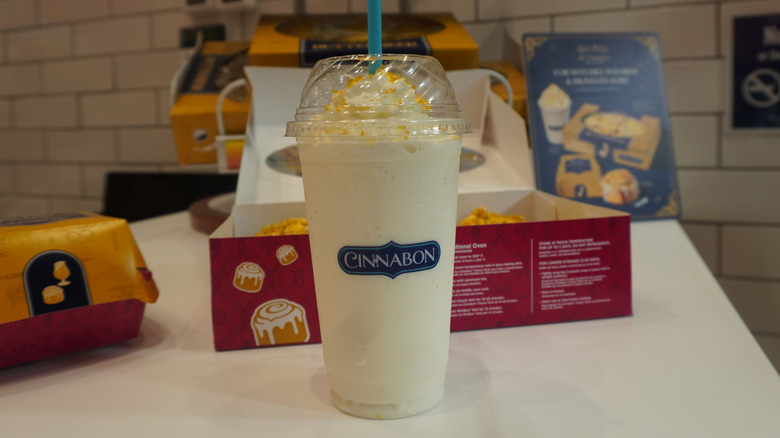 A Cinnabon Butterbeer-flavored Chillata on a Cinnabon store counter in front of a box of cinnamon rolls