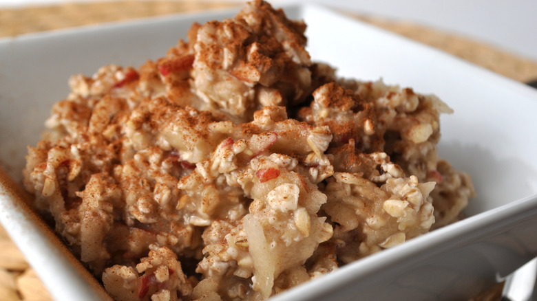 Cinnamon sprinkled on top of bowl filled with apple-crisp
