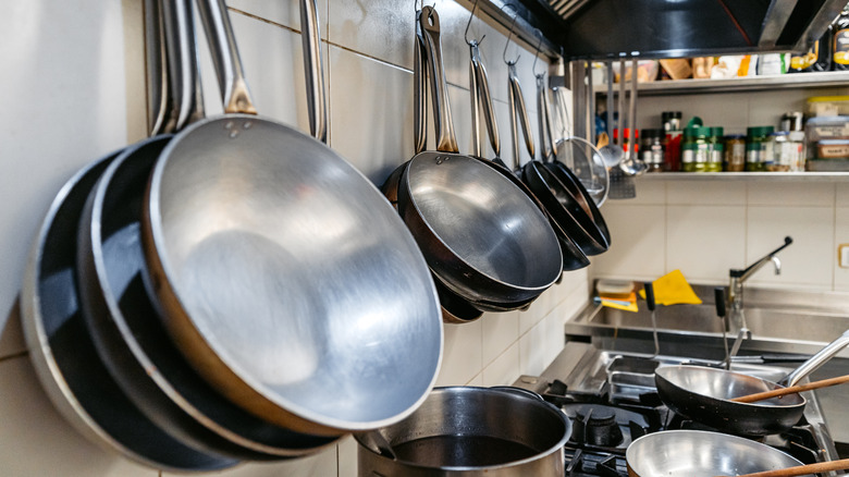 A hanging rack of stainless steel cookware