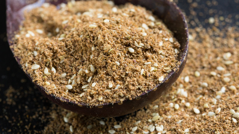 A closeup of a spoon of dukkah spice