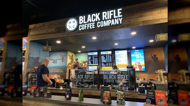 A customer waits at counter inside the Black Rifle Coffee Company Niceville, Florida location as staff member prepares order