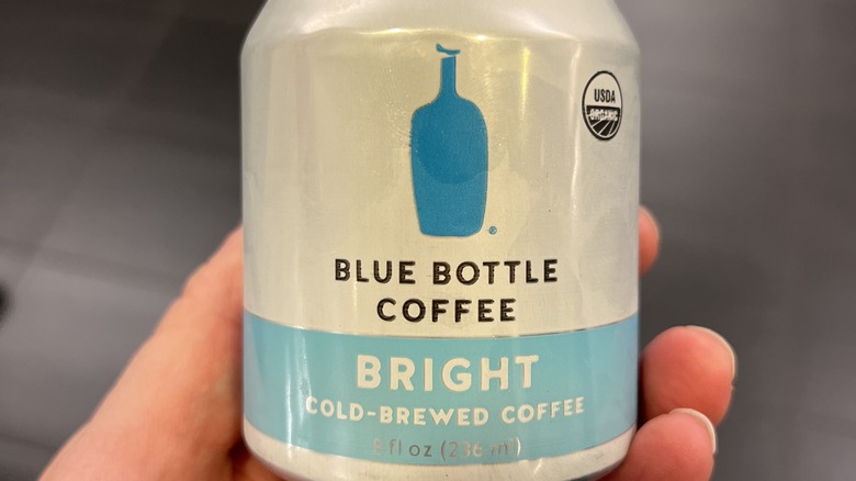 Hand holding Blue Bottle Coffee can