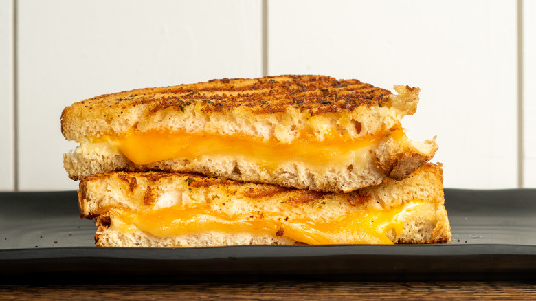 Close-up of a grilled cheese sandwich on a black plate