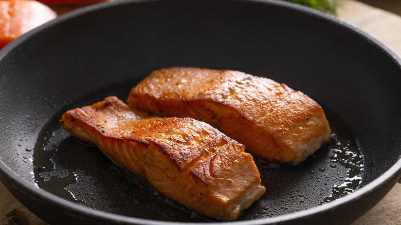 Salmon filets on a black frying pan