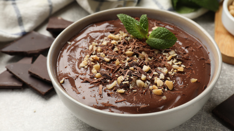 Delicious chocolate mousse in bowl gray table, close-up