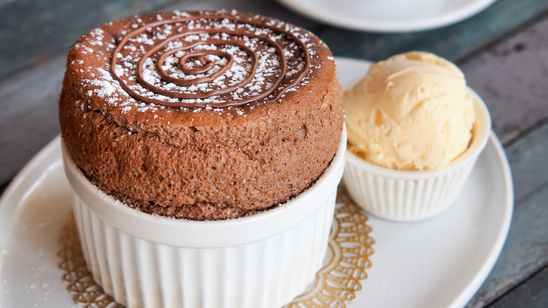 Chocolate souffle with vanilla ice cream on white plate . French traditional dessert