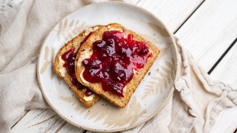 Two slices of sprouted grain brad with jam on top