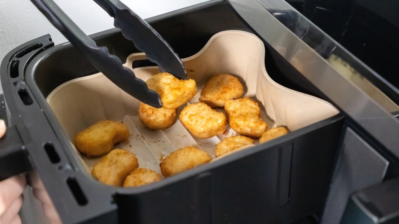 Nuggets being cooked in an air fryer.