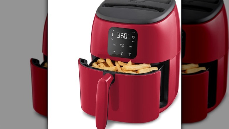 The Dash Tasti-Crisp DCAF260 air fryer with cooked fries in the basket compartment