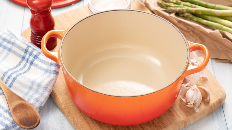An empty orange Dutch oven viewed from above.