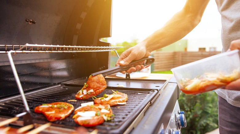 Person using gas grill to cook food