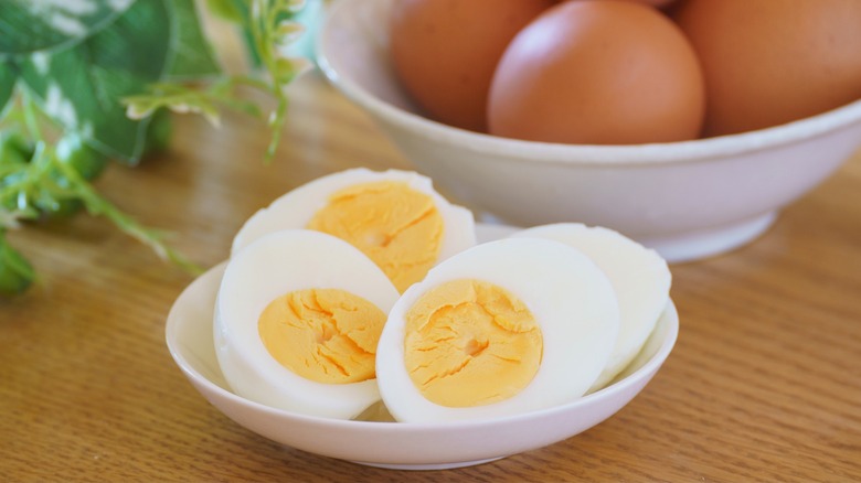 Hard-boiled eggs cut in half in white bowl