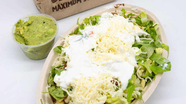 Chipotle burrito bowl with sour cream and side of guacamole