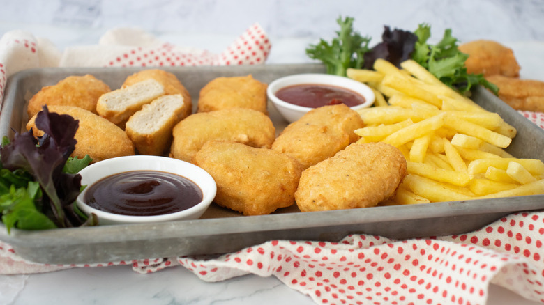 Copycat McDonald's chicken McNuggets on tray with sauces and fries
