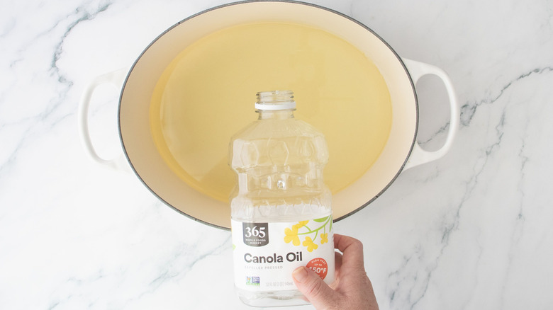 Canola oil pouring into large pot