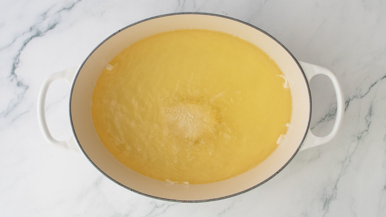 Chicken nugget frying in large pot of oil