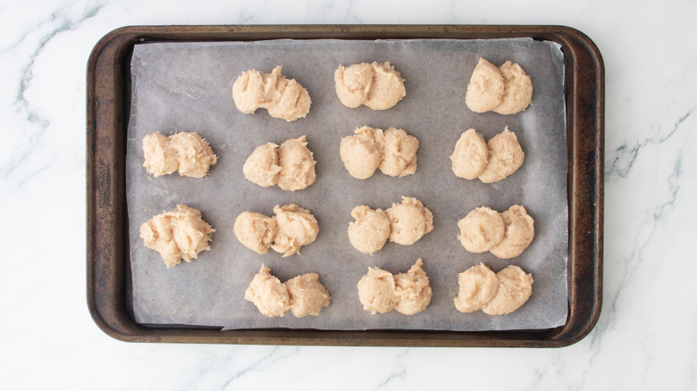 Chicken nugget filling mixture separated into portions on baking sheet