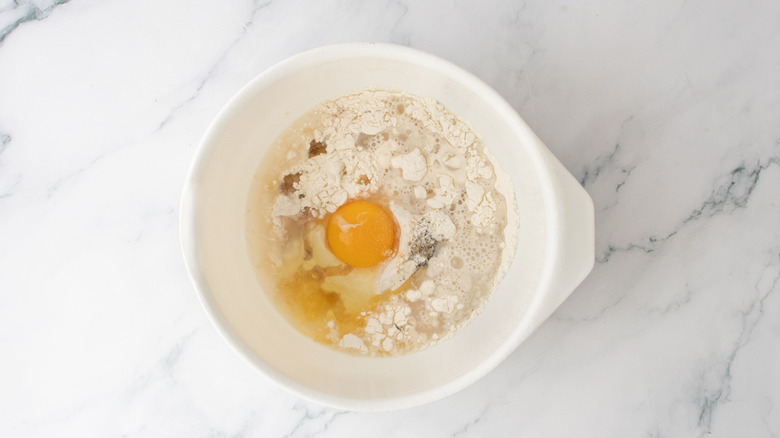 Flour, egg, and seasonings unmixed in bowl