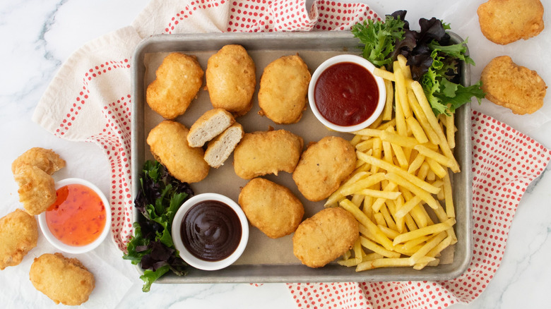 Copycat McDonald's chicken McNuggets on tray with sauces and fries