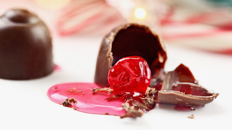 Three cordial cherries, one split open