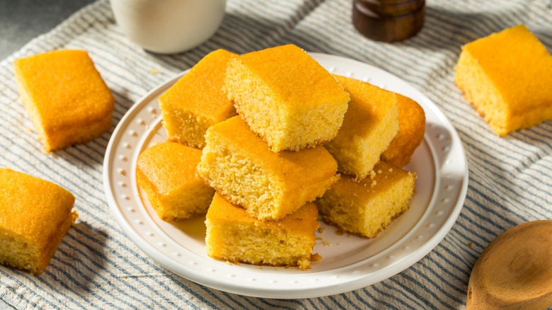 Pieces of cornbread stacked on a white plate