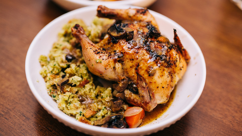 Cornish hen with stuffing in a white bowl