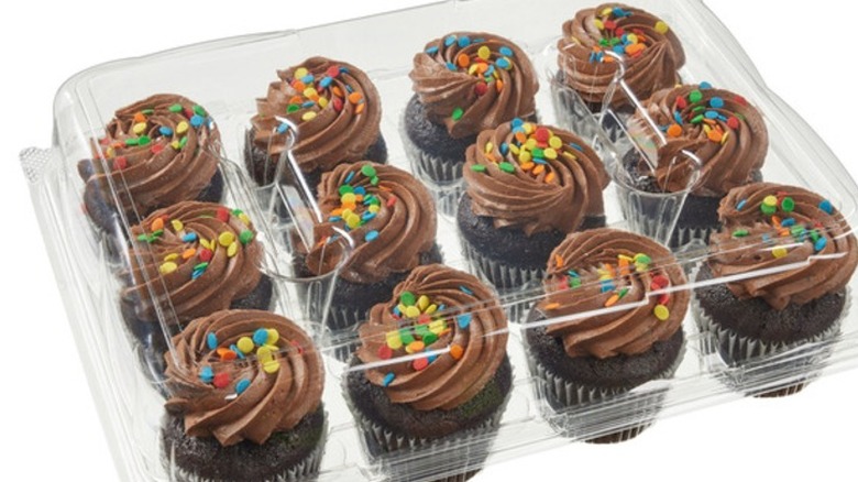 A package of 12 Kirkland Signature Chocolate Cupcakes with Chocolate Buttercream decorated with colored sprinkles on a white background.