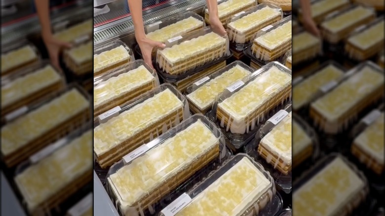 A person picking up one of the Pumpkin Spice Bar Cakes out of its cooler at Costco