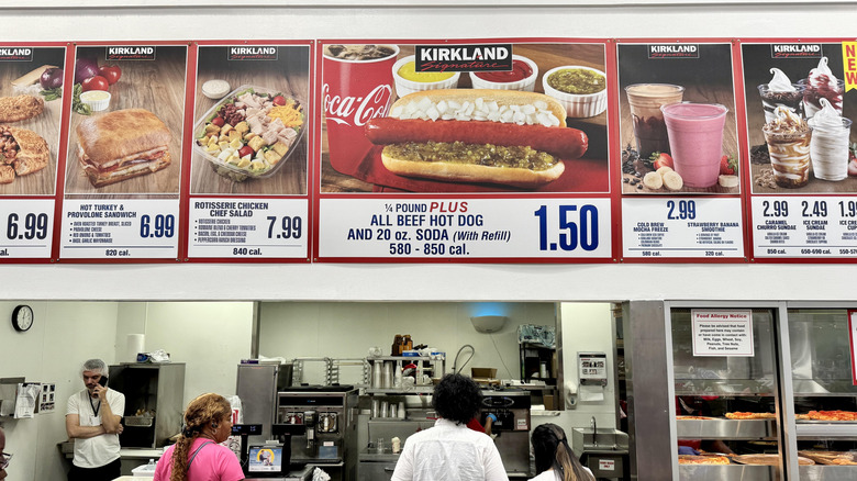 Costco food court sign with workers in the kitchen