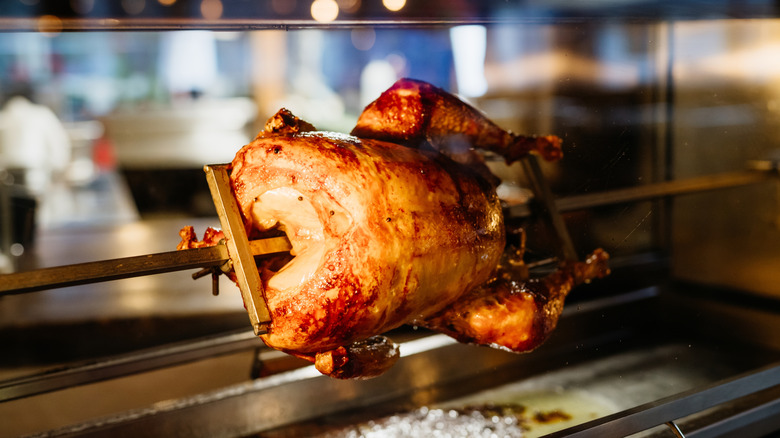 A cooking rotisserie chicken.