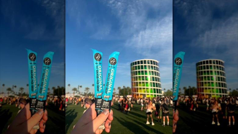 Hand holding two sticks of Archer Jerky at Coachella