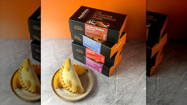 Nuchas Empanadas boxes and empanadas on a plate