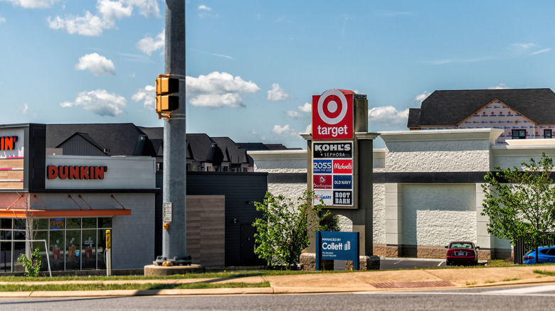 Strip mall entrance with a sign displaying all the stores