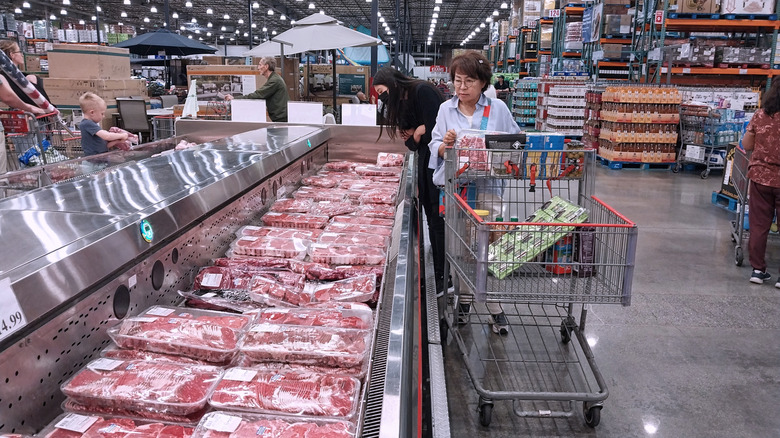 Costco shopper looking through meat section