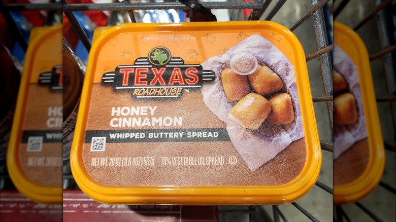 A container of the Texas Roadhouse Honey Cinnamon Whipped Buttery Spread in a shopping cart at Costco