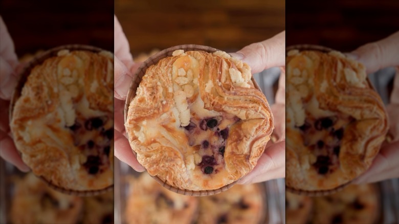 A Blueberry Caramelized Cheesecake Croissant from Costco held in someone's hand